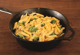 Lodge 3 Quart Deep Skillet campfire use shows outdoor cooking durability.