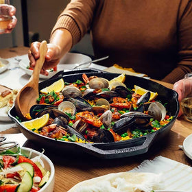 Dual-handled Lodge Chef Collection 14-inch skillet on stove for safe lifting and control.