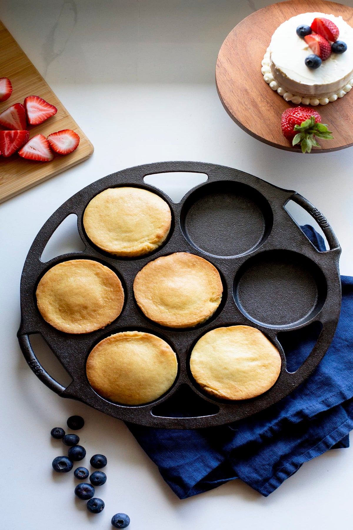 Lodge cast iron mini cake pan in use, baking diverse dishes with even browning