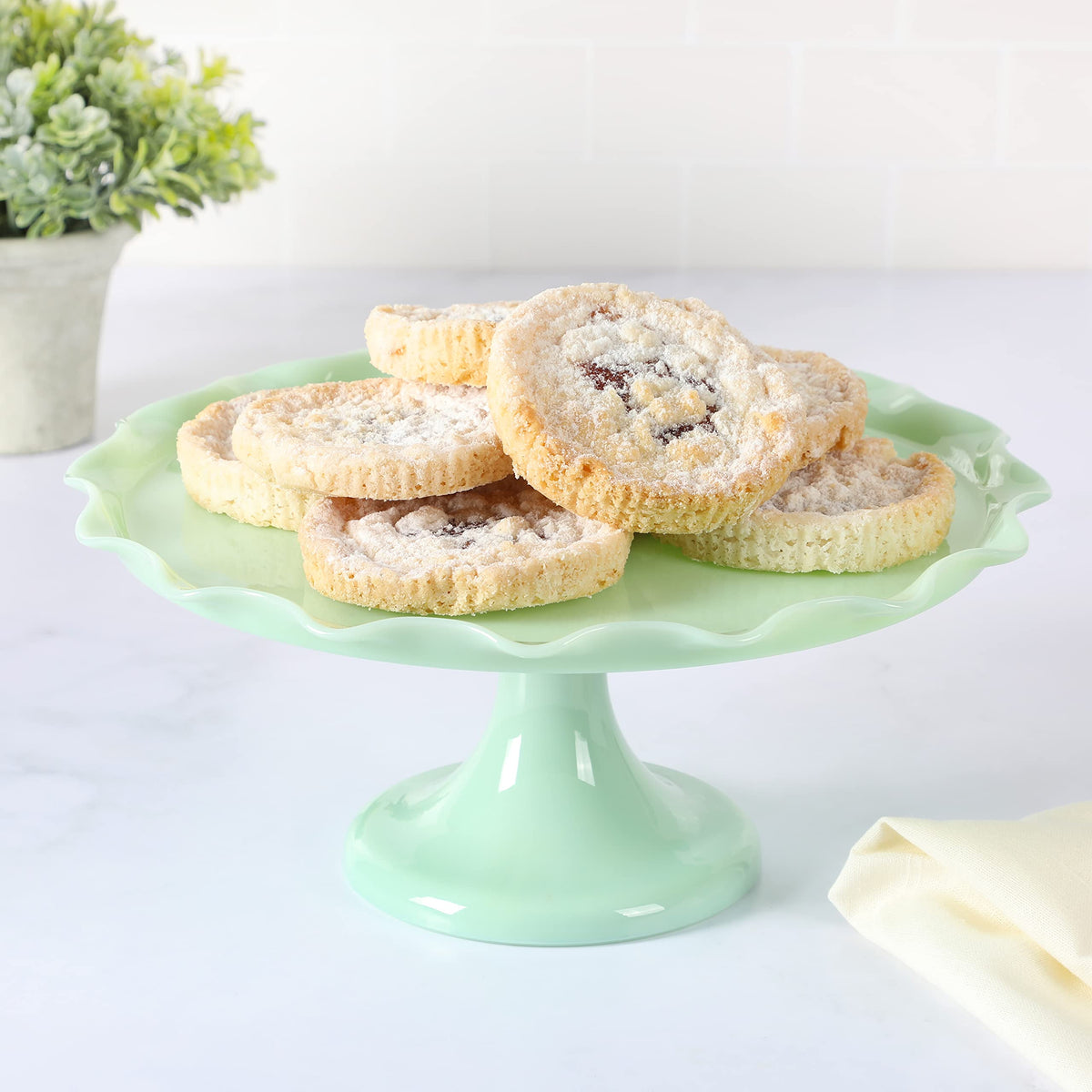 Martha Stewart Highbrook jadeite cake stand displaying cakes for a chic party centerpiece.