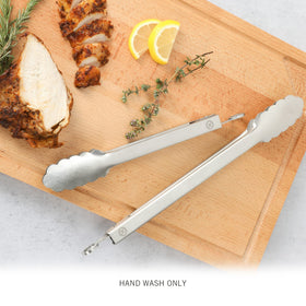 Martha Stewart Richburn tongs with scalloped heads gripping slippery foods securely.