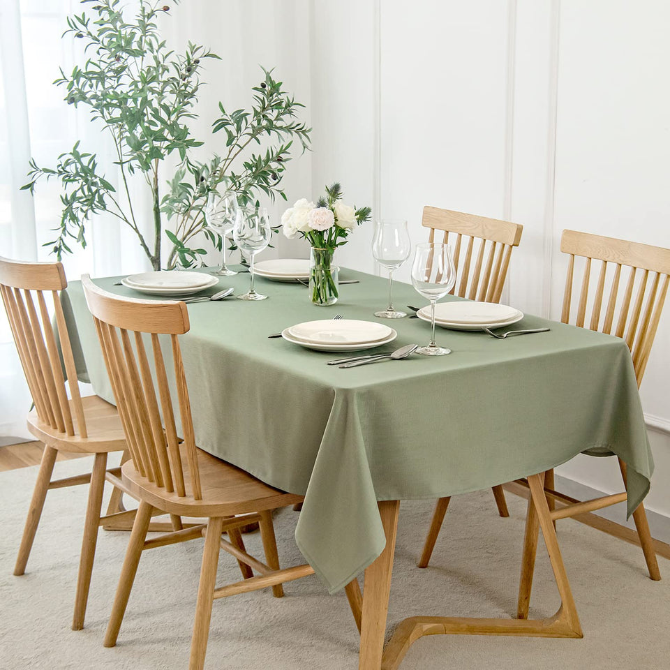 Maxmill rectangle-slubby-textured tablecloth in sage green enhances an elegant dining setting.