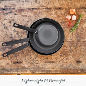 Merten & Storck ergonomic triple-riveted handle carbon steel pan for secure grip.