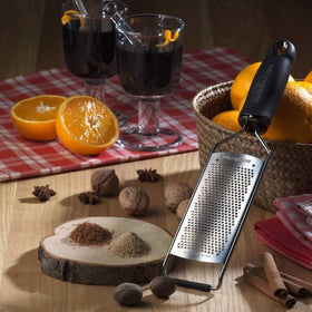 Microplane Gourmet Series grater shaving ginger and garlic into powder-like bits.