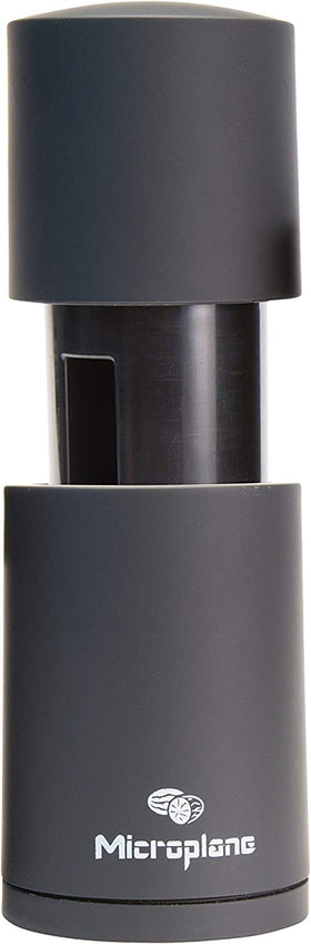 Microplane nutmeg grater closeup highlights precise grating without knuckles.