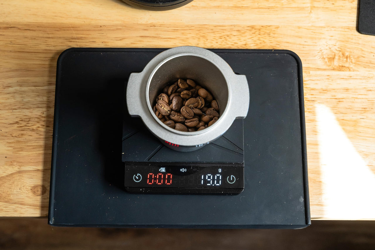 MiiCoffee mat features corner overhang design to contain spills during tamping.
