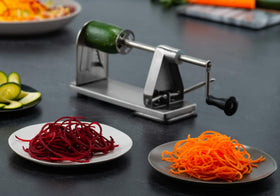 MITBAK spiralizer with suction base in action for stable counter use.