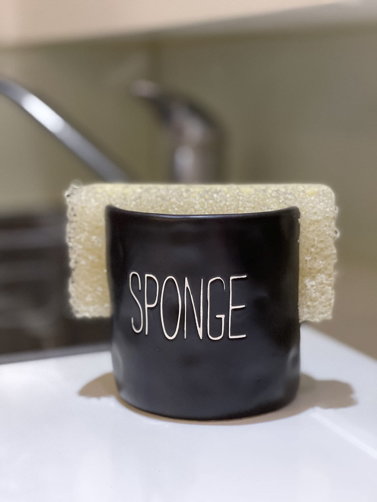 Mud Pie ceramic sponge holder sits on the counter for easy access.