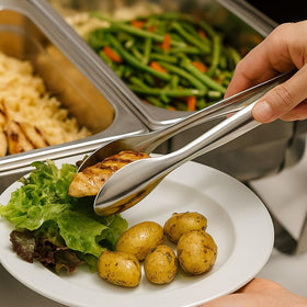 Natier premium stainless steel serving tongs 9-inch beside bread basket for convenient service.