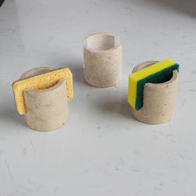 Nawgnail natural travertine sponge holder close-up showing a porous surface for quick drying.