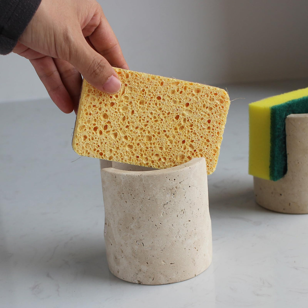 Nawgnail surface-absorbent travertine caddy dries sponges quickly and resists rust.