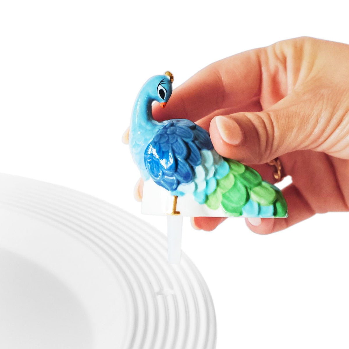 Nora Fleming Fancy Feathers Peacock mini shows hand-painted details for shelf decor.