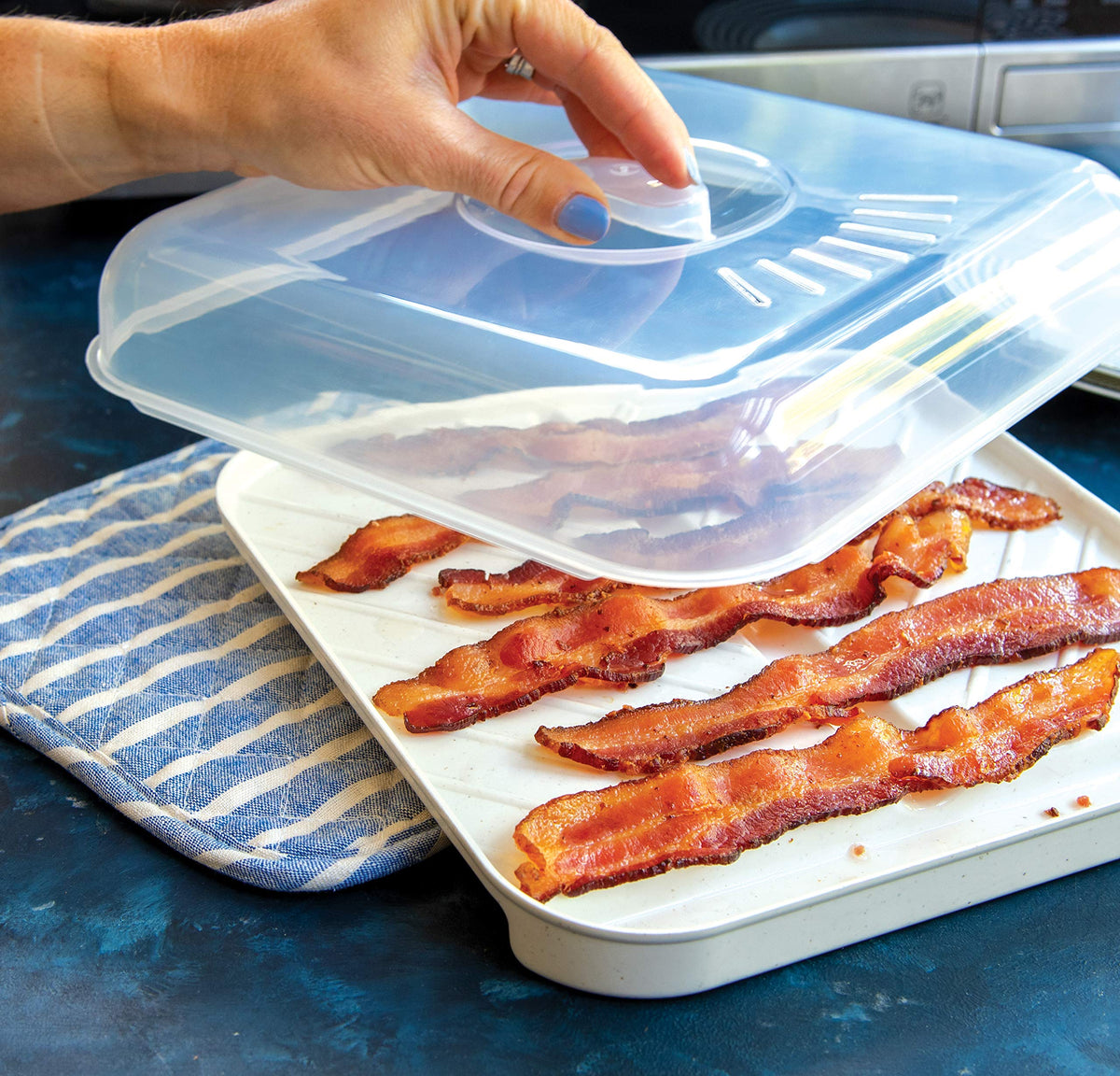 Nordic Ware lid and tray can become hot; use a mitt for safe handling.