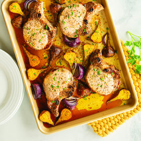 Nordic Ware Naturals half sheet surrounded by roasted vegetables and herbs