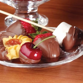Nostalgia fondue fountain with berries and fruits for dessert options.