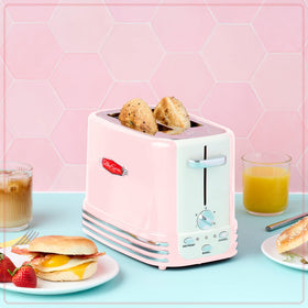 Nostalgia pink toaster illuminated controls for bagel, defrost, and cancel options