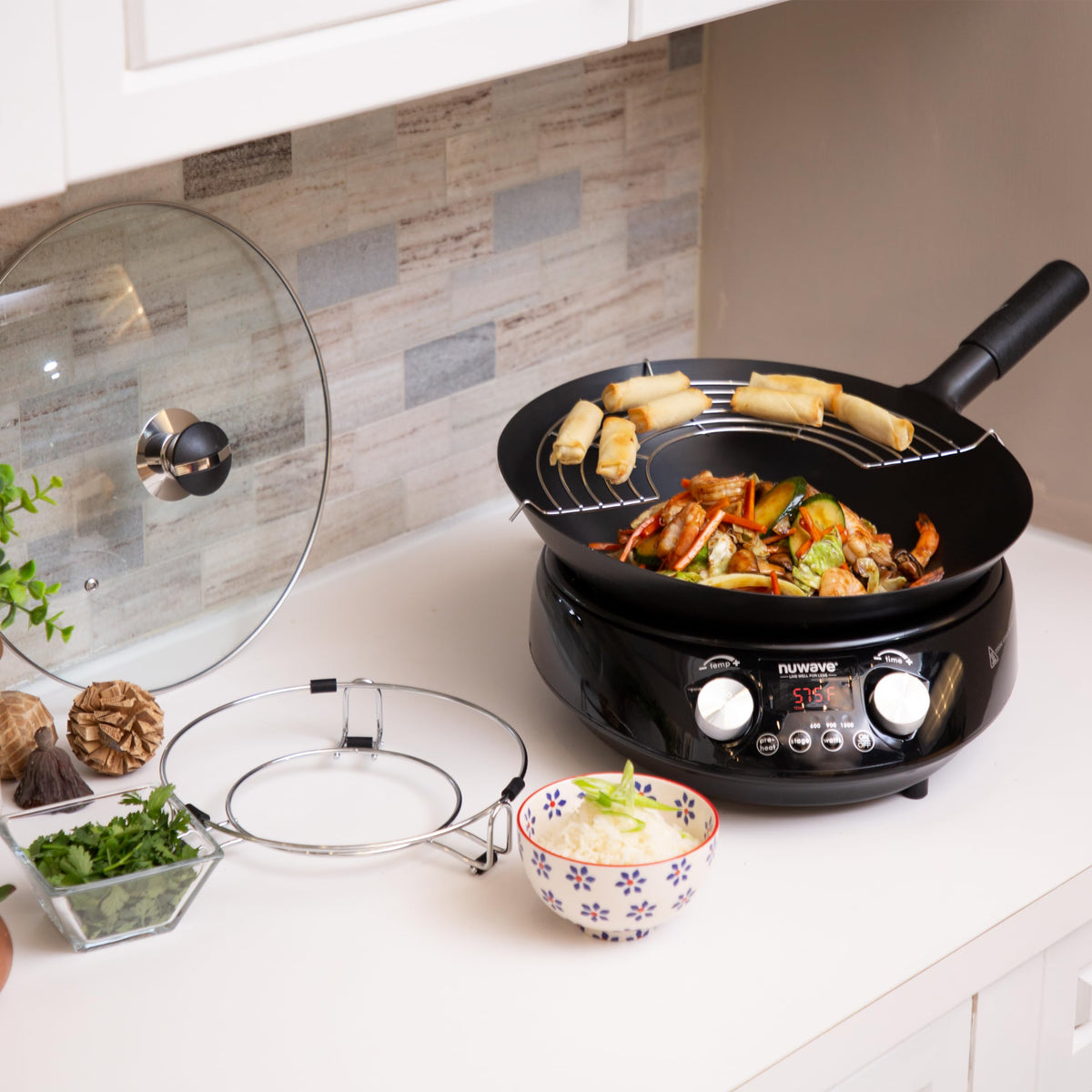 Nuwave Mosaic metal wok stand supports easy serving and storage.