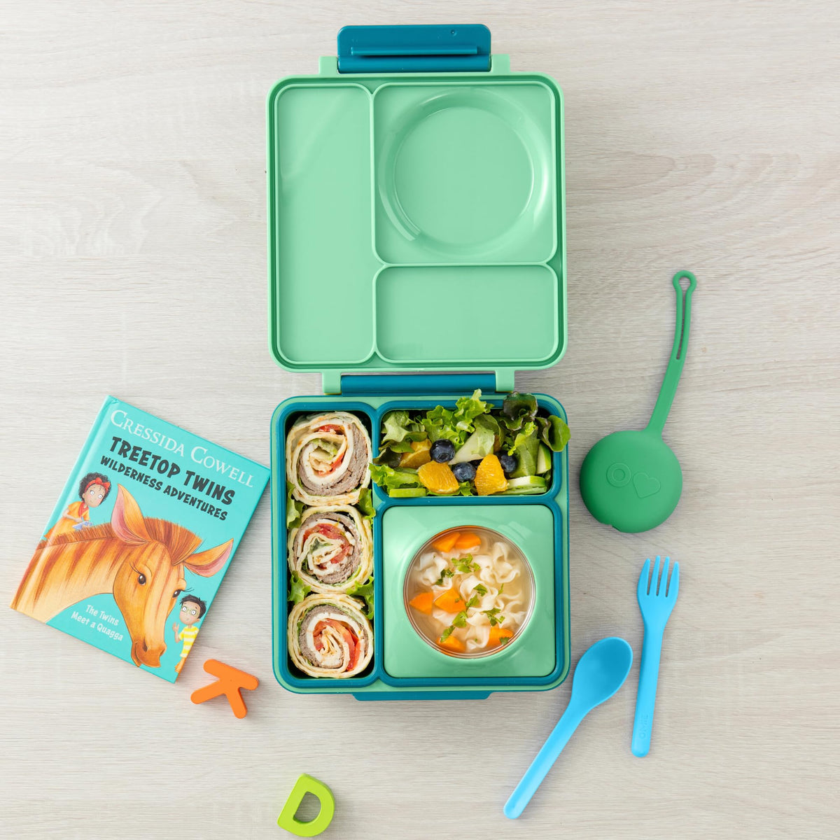 OmieBox mint green fork nested inside the pod for travel