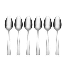 Oneida Aptitude teaspoons on a dining table, highlighting durable stainless steel for daily use.