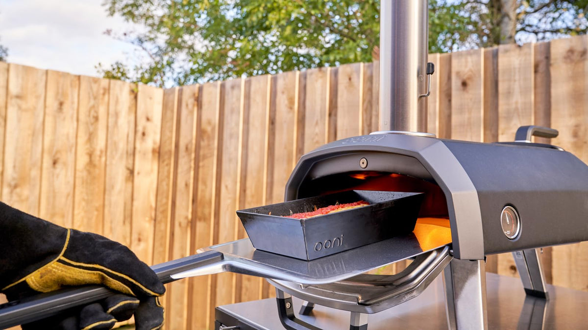 Ooni metal pizza peel in use for dough transfer to oven