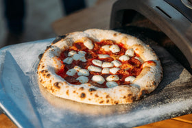 Ooni long-handle peel enables precise placement from hot ovens