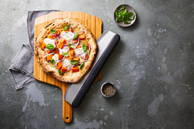 Ooni bamboo paddle supports even handling for crispy crusts.