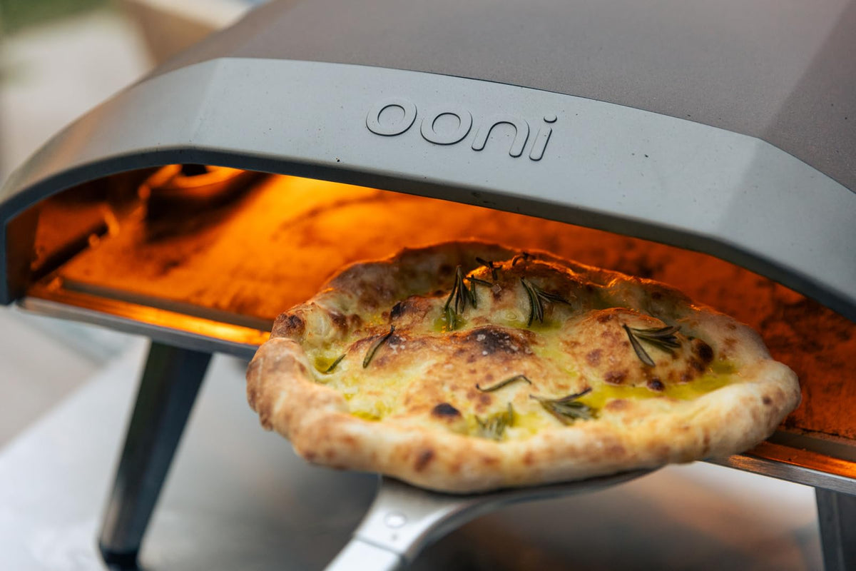 Ooni pizza turning peel in use during a bake.