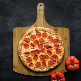 Outset pizza peel durable food-grade design for versatile serving and slicing.