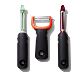 OXO Good Grips 3-Piece Peeler Set peeling beet with sharp, rustproof blades.