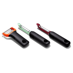 OXO Good Grips 3-Piece Peeler Set in use on a prep board.