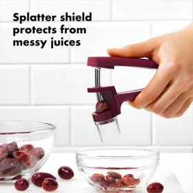 OXO Good Grips Cherry and Olive Pitter includes a removable splatter shield protecting workspace.