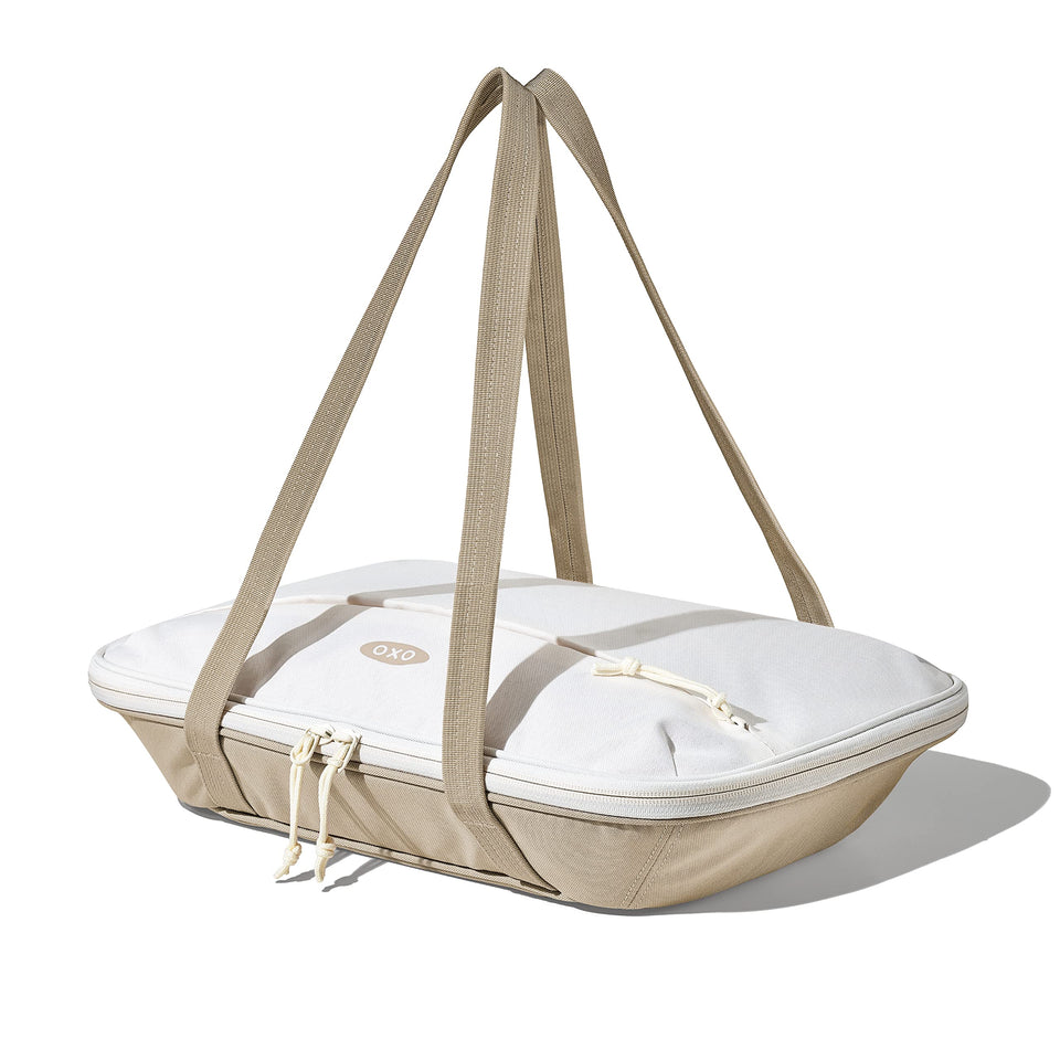 OXO Good Grips insulated casserole carrier in oat with a front pocket for utensils.