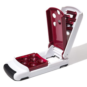 OXO Good Grips Quick Release Multi Cherry Pitter in use, drops pitted cherries into bowl