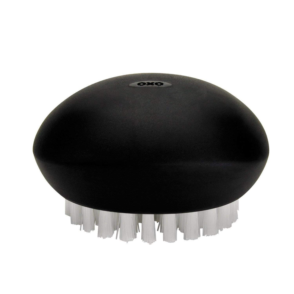 OXO Good Grips Vegetable Brush handle detail shows a flexible, non-slip grip in action.