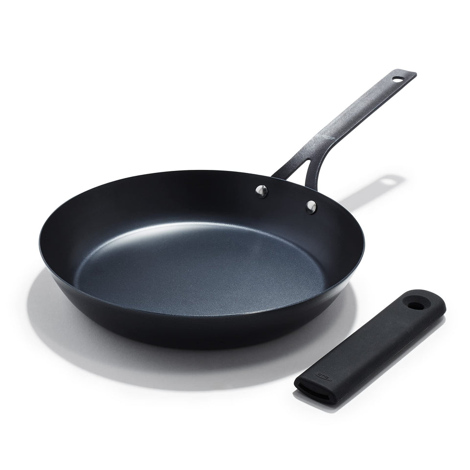 OXO Obsidian 10in carbon steel frying pan on stove enabling even heat sear.