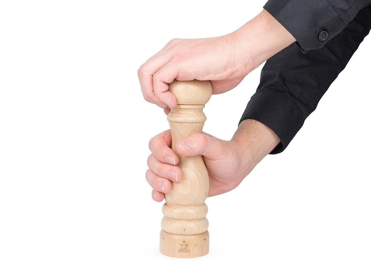 Peugeot Paris u-select pepper mill close-up, showing wood grain and steel mechanism.