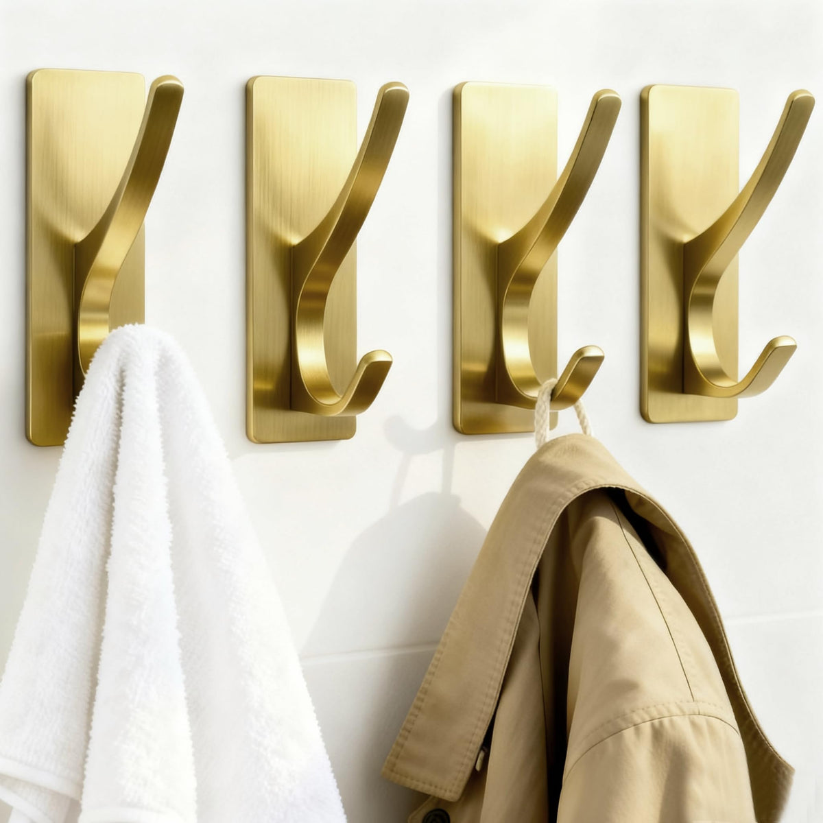 Pickpiff brushed gold self-adhesive coat hook holding towels in a bathroom
