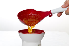 PREPWORKS red canning scoop clipped to pot rim for easy access.