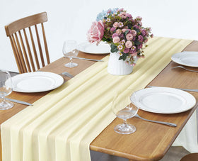 Pufogu light yellow chiffon table runner cascading over a banquet table.