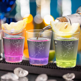 Qipecedm shot glasses on a bar counter ready for quick pours.
