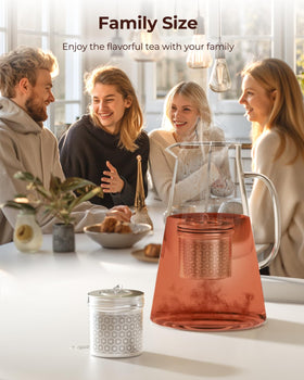 Large tea infuser perched on pitcher rim during brewing.