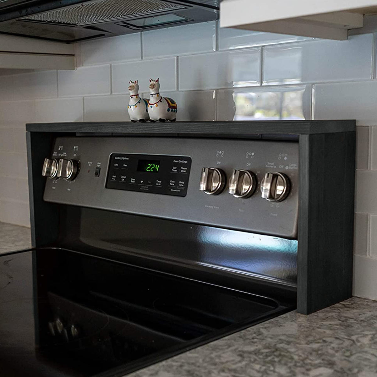 Ebony-finish spice rack mounted above stove for easy reach.