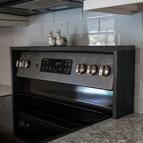 Ebony-finish spice rack mounted above stove for easy reach.