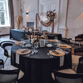 RestfulGlow 8-pack black round tablecloth set on a wedding table for guests