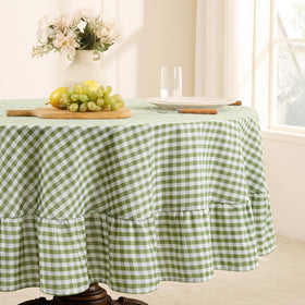Romanstile gingham-ruffled round tablecloth in sage adds elegant outdoor charm.