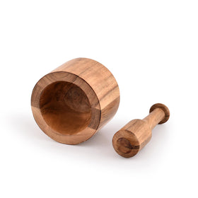 Samhita Acacia mortar and pestle with ground spices ready for cooking.