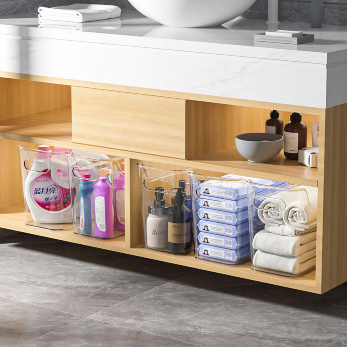 SCPB clear bin in bathroom cabinet, with dividers separating items.