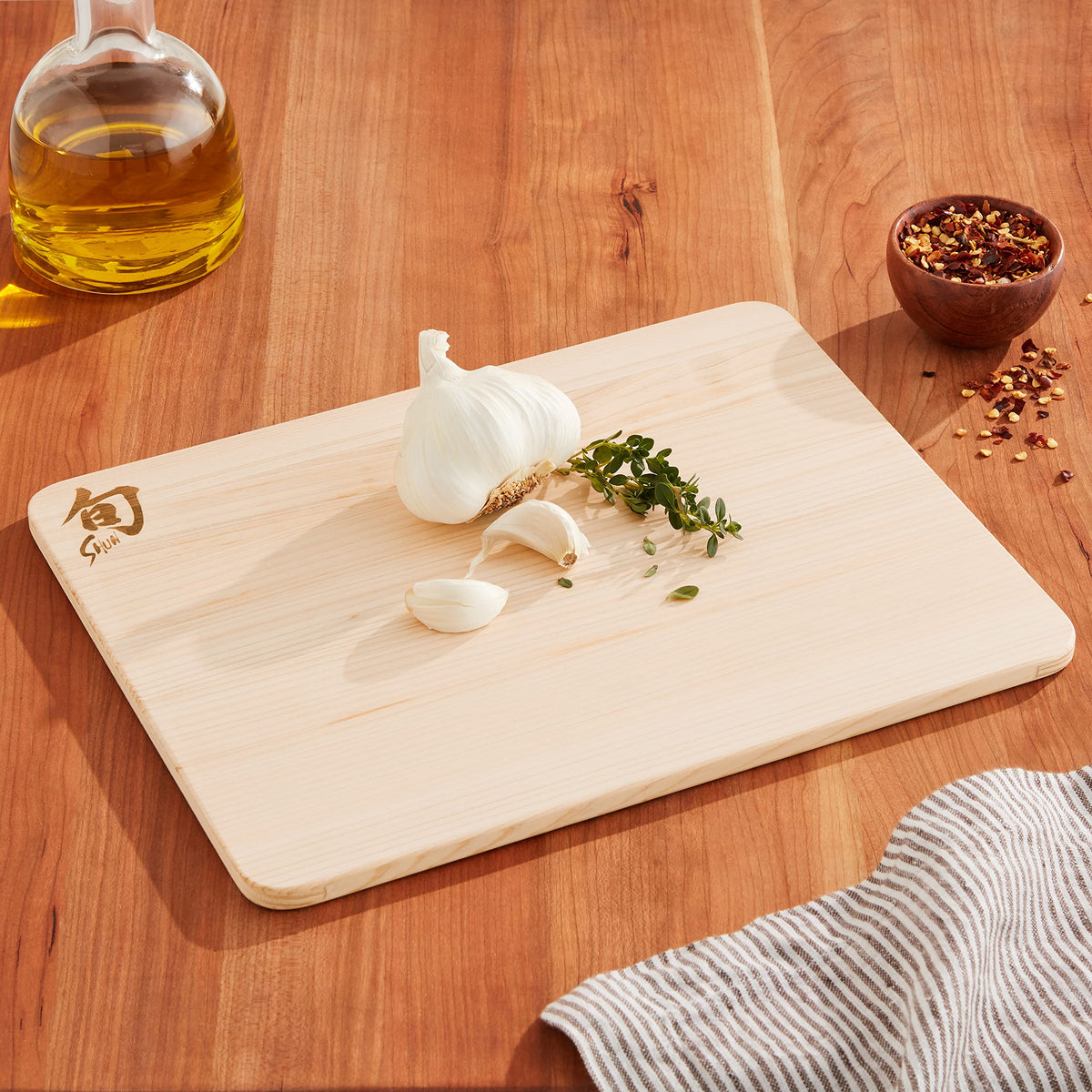Shun Small Hinoki Cutting Board in use, knife cutting smoothly on hinoki surface.
