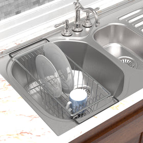 Chrome finish dish drainer over sink holding glasses after washing