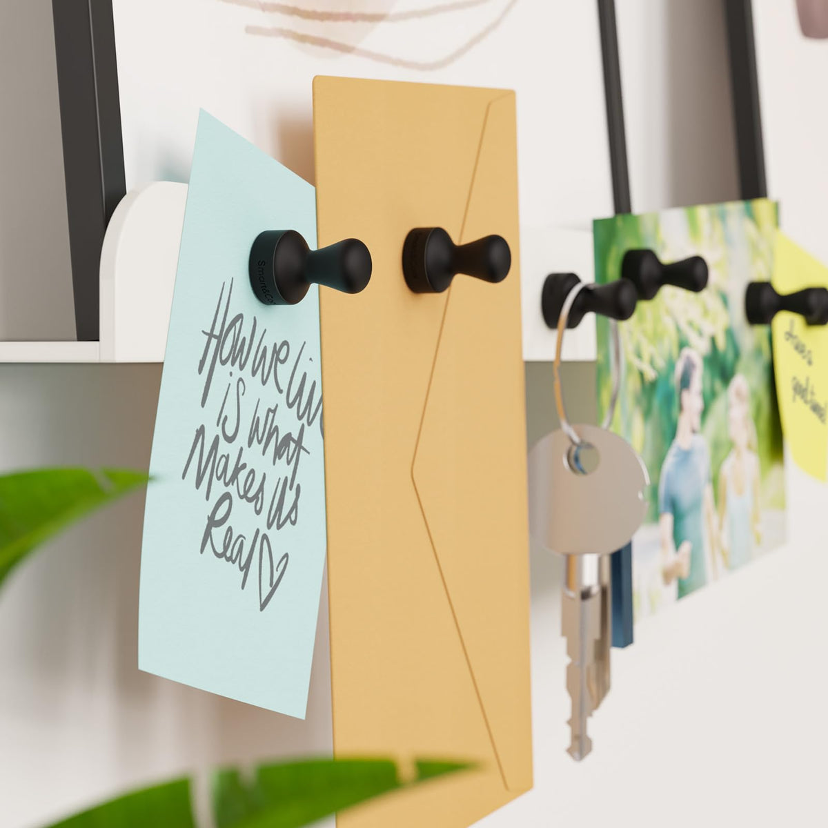 Smart&Cool magnets holding more than ten sheets of paper on a fridge.